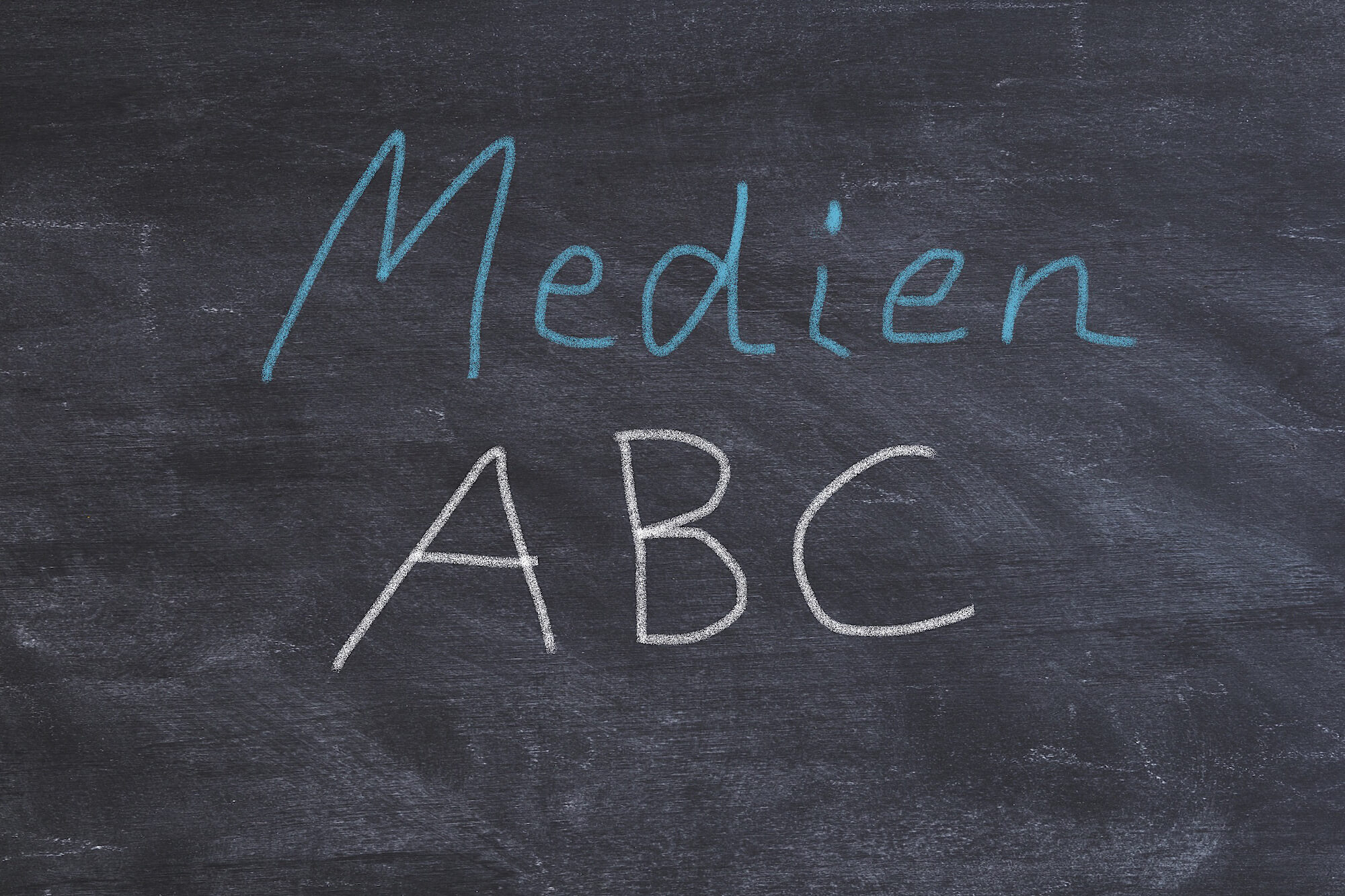 Auf einer Schultafel stehen die Worte Medien ABC geschrieben