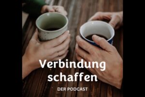 Zwei Kaffeetassen mit Händen von zwei Menschen, die sich gegenüber an einem Tisch sitzen. Runter steht Verbindung schaffen Podcast.
